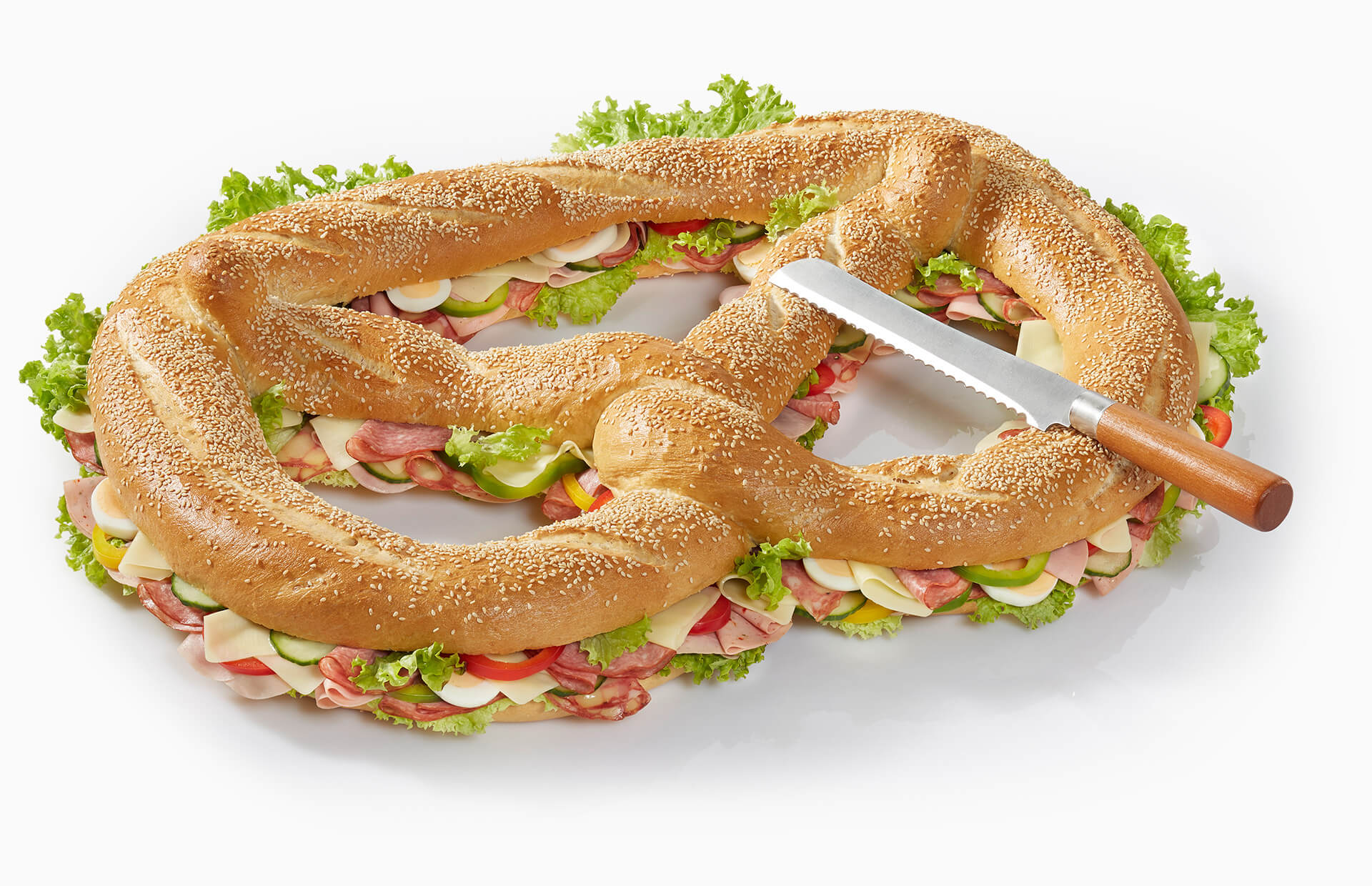 Expressbrezn, gemischt gefüllt, garniert mit Salat, Gurke, Ei, Paprika mit Messer