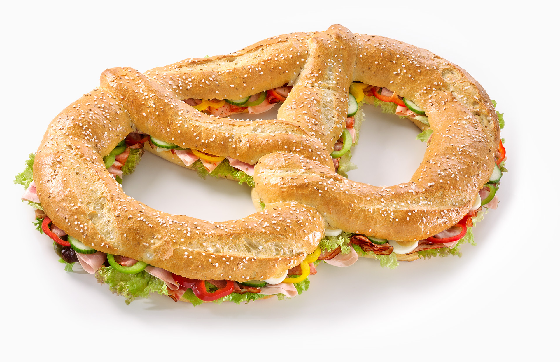 Riesen-Partybrezn aus Dreikornteig belegt mit Wurst, Schinken, garniert mit Salat, Gurke, Ei und Paprika
